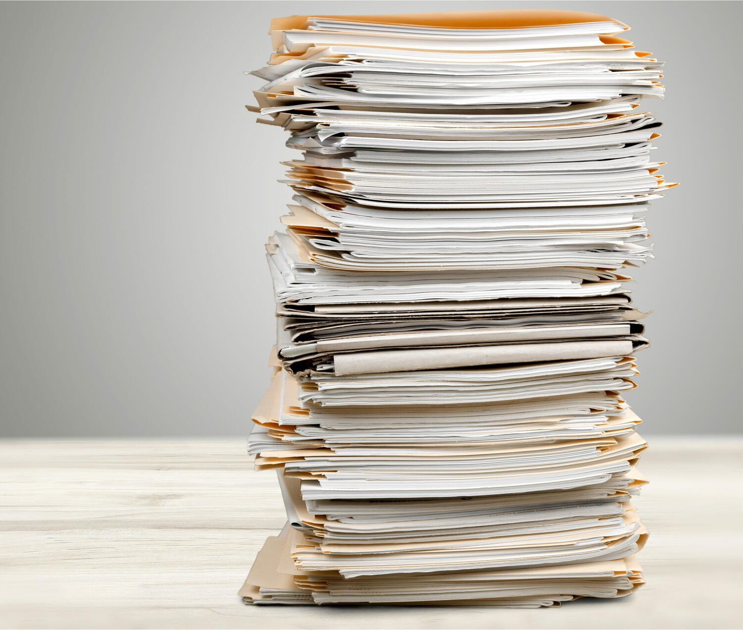 Tall stack of filed papers on a table